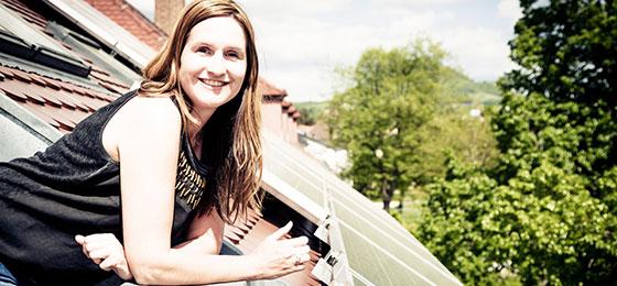 The image shows a woman on a balcony.