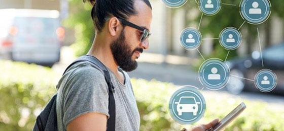 The image shows a man booking a carsharing vehicle with a tablet.