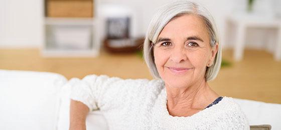 The image shows a woman sitting on a sofa.